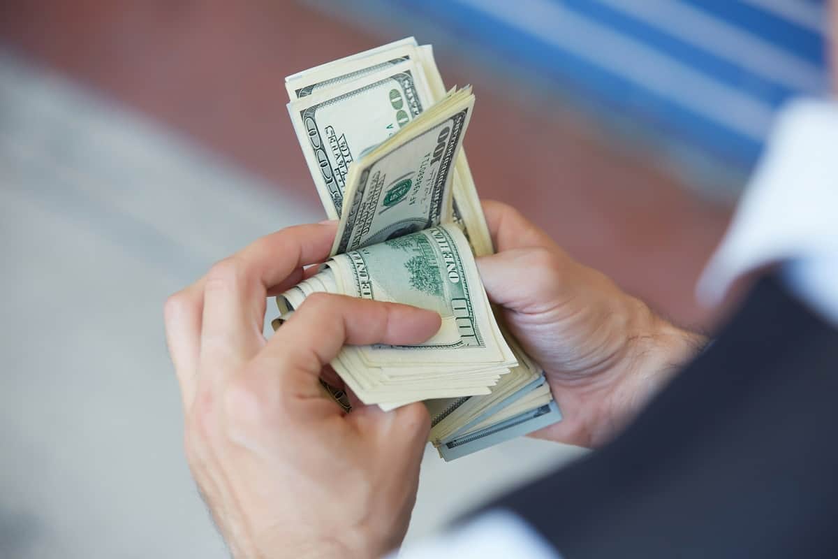 Man holding $10,000 in cash