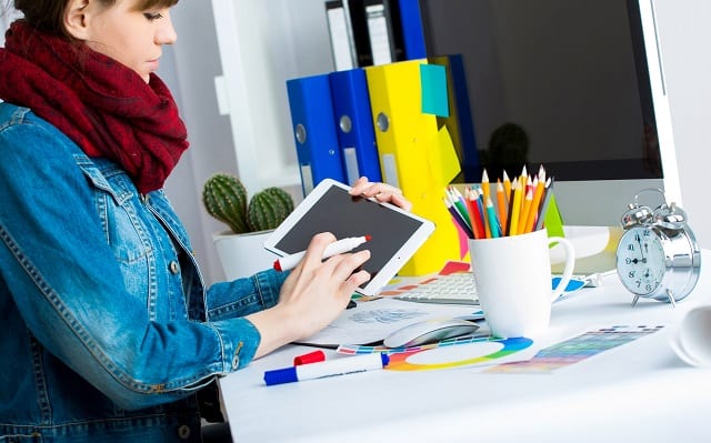 woman designing graphics on a tablet