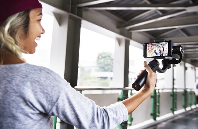 Woman recording YouTube video with smartphone